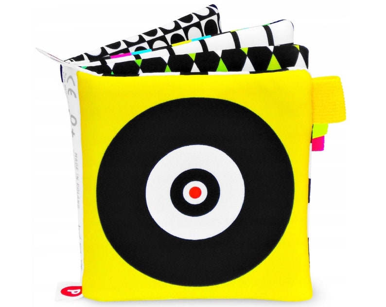 Pattern resembling a shooting target or CD. The periphery is yellow, the circles are black and white and the central dot is red. The following pages are also strongly contrasting, black and white, as well as vividly colored and geometrically varied.