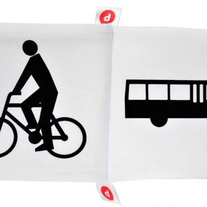 May include: Black and white illustration of a person riding a bicycle and a bus on a white background. The illustration is part of a fabric book.