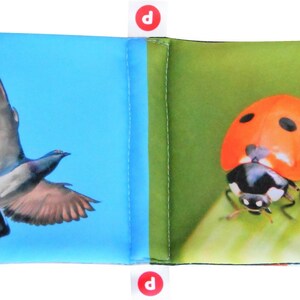 May include: A blue fabric book with a picture of a pigeon on one side and a ladybug on the other side.