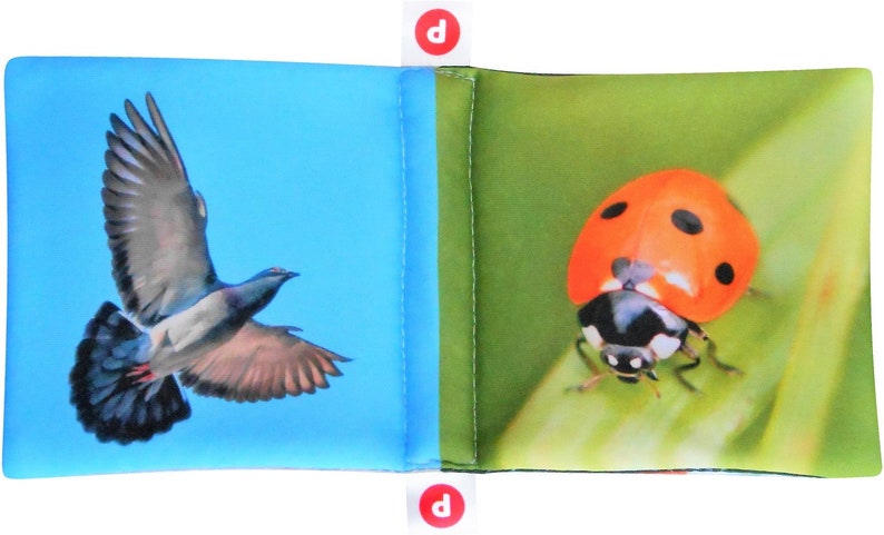 May include: A blue fabric book with a picture of a pigeon on one side and a ladybug on the other side.