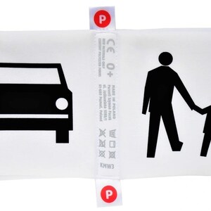 May include: White pillow with black illustrations of a car, a person walking, and a child walking. The pillow has a label with the text "CE 0+" and "MADE IN POLAND".