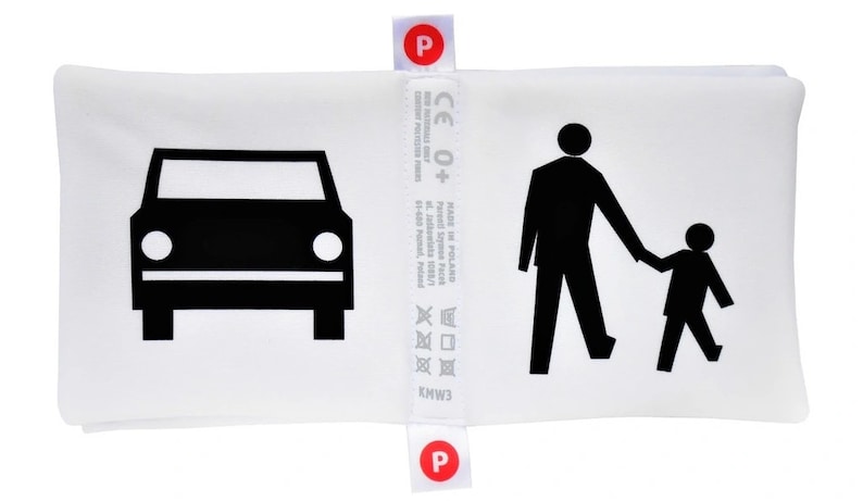 May include: White pillow with black illustrations of a car, a person walking, and a child walking. The pillow has a label with the text "CE 0+" and "MADE IN POLAND".
