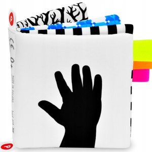 Contrasting silhouette of a baby's hand. The following pages show the same hand from the cover in strongly contrasting patterns, black and white and bright vivid colors. Each page has bright little tabs in neon colors.