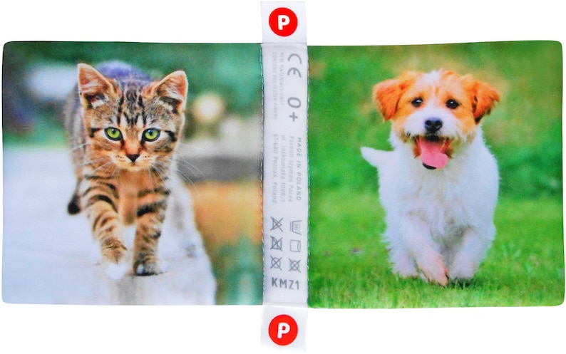 May include: A colorful fabric panel with a brown tabby cat walking on a white surface and a white and brown dog running on green grass. The panel has a white label with the text "CE 0+ Made in Poland" and washing instructions.