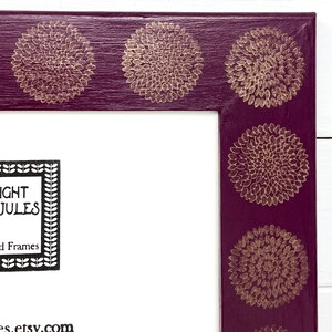 May include: A purple picture frame with gold floral designs around the edge. The frame has a white mat and the text "NIGHT JULES" and "Framed Frames" is printed in black on the mat. The text "es.etsy.com" is printed in black at the bottom of the mat.