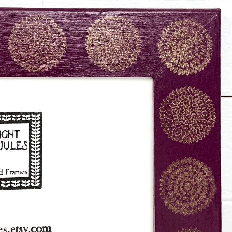 May include: A purple picture frame with gold floral designs around the edge. The frame has a white mat and the text "NIGHT JULES" and "Framed Frames" is printed in black on the mat. The text "es.etsy.com" is printed in black at the bottom of the mat.
