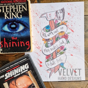 May include: A book and DVD of "The Shining" are next to a drawing of an axe with the words "All work and no play makes Jack a dull boy." The drawing has colorful flowers and red splatter.