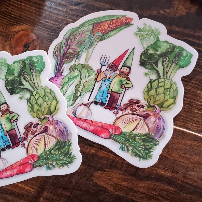 May include: Two gnomes with white beards and red hats stand in a garden with a variety of vegetables, including corn, broccoli, artichokes, onions, carrots, and garlic. The gnomes are holding gardening tools and are surrounded by lush greenery.