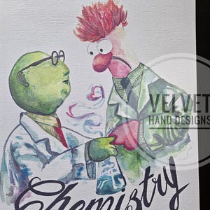 Peut inclure: Illustration à l'aquarelle représentant deux personnages des Muppets en blouses de laboratoire, l'un portant des lunettes. Le mot "Chemistry" est écrit en cursive en bas. L'image a un fond texturé et un filigrane "Velvet Hand Designs".