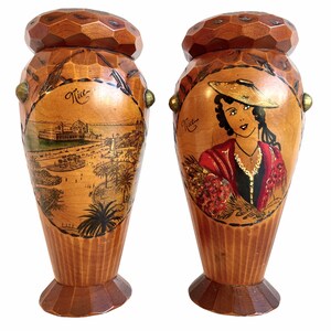 May include: Two wooden vases with hand-painted scenes of Nice, France. One vase features a woman in a red dress and hat, the other shows a cityscape with palm trees.