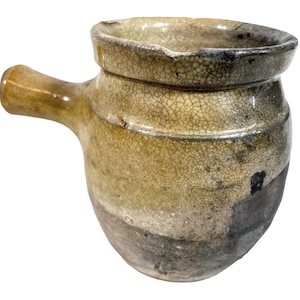 May include: A small, round, ceramic pot with a handle. The pot has a crackled glaze in shades of brown, white, and gray.