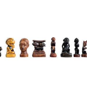 May include: A set of nine wooden chess pieces with intricate carvings. The pieces are painted in shades of brown, black, and gold. The pieces are arranged in a row on a white background.