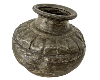 Könnte beinhalten: Ein kleiner, grauer Metalltopf mit rundem Körper und einer breiten Öffnung. Der Topf hat ein dekoratives Design um die Mitte.