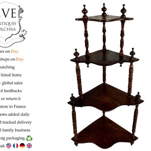 May include: A three-tiered corner shelf made of dark wood with turned spindles and decorative finials. The shelf has a scalloped edge and is perfect for displaying small items.