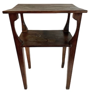 Puede incluir: Una mesa auxiliar de madera marrón oscuro con dos estantes y un diseño sencillo. La mesa tiene una parte superior y un estante inferior rectangulares, con cuatro patas que se ensanchan ligeramente en la parte inferior.