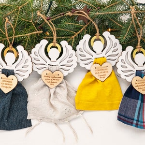 May include: Five wooden angel ornaments with fabric wings and personalized heart-shaped tags. The tags have messages of remembrance and include names and dates. The ornaments are a thoughtful way to honor loved ones.