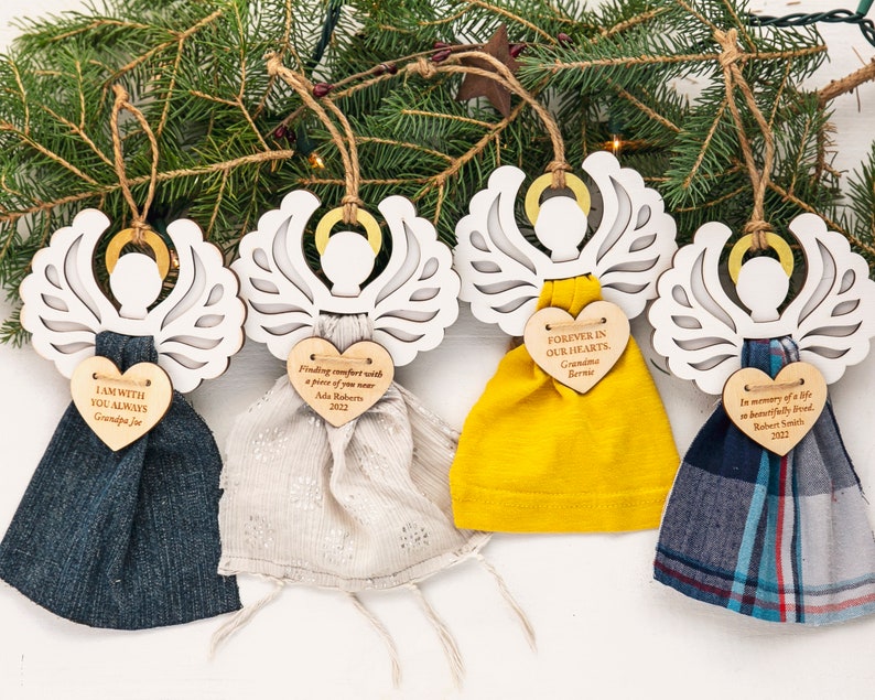 May include: Five wooden angel ornaments with fabric wings and personalized heart-shaped tags. The tags have messages of remembrance and include names and dates. The ornaments are a thoughtful way to honor loved ones.