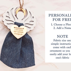 May include: White wooden angel ornament with a heart-shaped wooden tag that says "I am with you always Grandpa Joe". The angel has a blue denim fabric attached to it. The text "PERSONALIZE FOR FREE" is written in black text on a white background. The text "1. Choose a Phrase 2. Add a Name" is written in black text on a white background. The text "NOTE Fabric size and simple instructions come with each ornament so you can easily add your loved one's fabric" is written in black text on a white background.