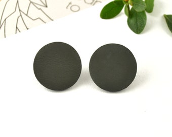 May include: A pair of dark green leather circle stud earrings.