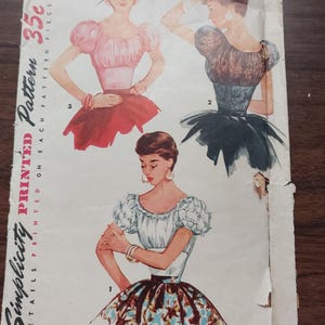 May include: Vintage Simplicity sewing pattern #1929 for a blouse with puffed sleeves. The pattern is printed on white paper with black text and illustrations of three women wearing different versions of the blouse. The pattern is for size 11, bust 29 inches. The text "Simplicity Printed Pattern 35c Printed One Each Pattern Piece" is printed on the left side of the pattern.