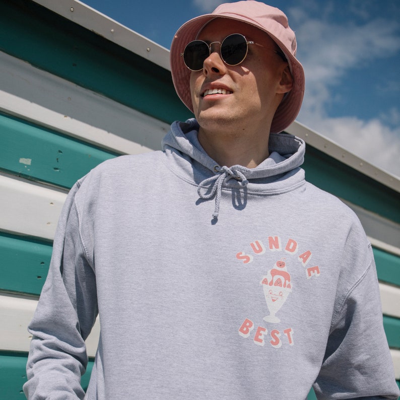 May include: A gray hoodie with a pink ice cream sundae graphic and the text "SUNDAE BEST" in pink letters.