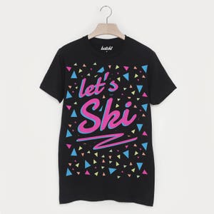 May include: Black t-shirt with a colourful geometric pattern and the text "Let's Ski" in pink and blue lettering.