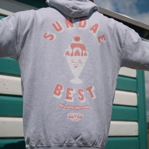 May include: Gray hoodie with a graphic of a sundae ice cream with the text "SUNDAE BEST" and "Make every day a sundae" below the graphic. The graphic also includes the text "Bob's Ice Cream" with a logo.