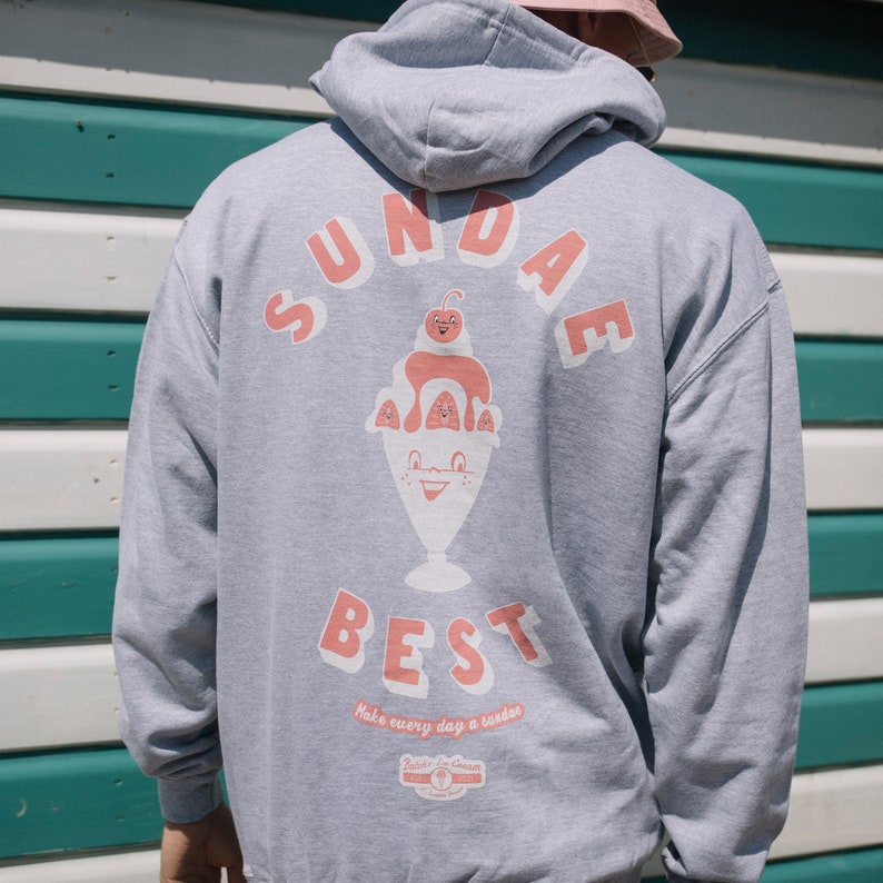 May include: Gray hooded sweatshirt with a graphic of a cartoon ice cream sundae with the text "SUNDAE BEST" and "Make every day a sundae" printed on the back.