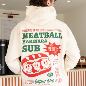 Moletom com capuz gráfico unissex Meatball Marinara Sub em baunilha