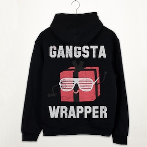 May include: Black hooded sweatshirt with a white graphic print of a red gift box wearing sunglasses and the text "Gangsta Wrapper".