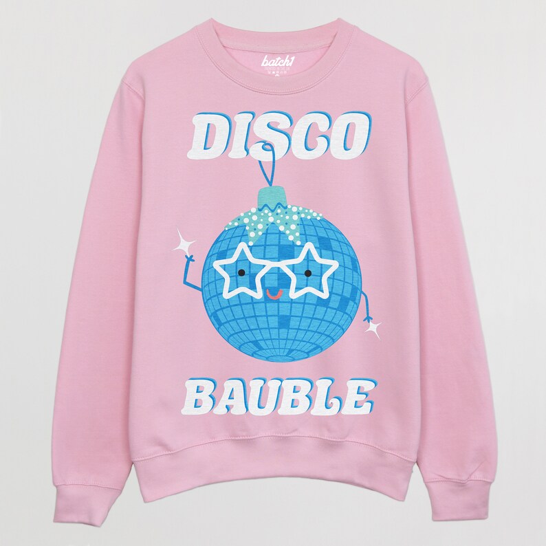 May include: Pink sweatshirt with a white graphic of a disco ball wearing sunglasses and the text "DISCO BAUBLE".