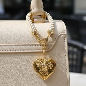 Fashion Trend Accessory Heart Locket Design Purse Charm Collection Gold Chain Detail Bag Decoration Style Rose Engraved Feature Handbag Embellishment Idea Y2K Aesthetic Appeal Vintage Inspired Look Modern Fashion Statement Gold Filled