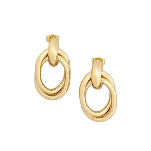 May include: A pair of gold-colored earrings. Each earring features two interlocking oval loops, creating a layered effect. The earrings have a post-back closure and a polished finish, reflecting light.