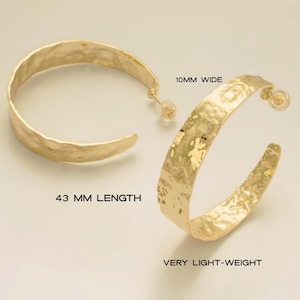 May include: Gold-toned hoop earrings with a hammered texture. The earrings are 43 mm in length and 10 mm wide. The text on the image says "VERY LIGHT-WEIGHT".