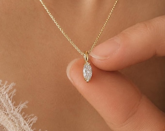Op de afbeelding: Een delicate gouden ketting met een marquise-geslepen diamanten hanger. De hanger wordt vastgehouden door een kleine gouden zetting en hangt aan een fijne gouden ketting. De ketting wordt getoond tegen een zachte, neutrale achtergrond.