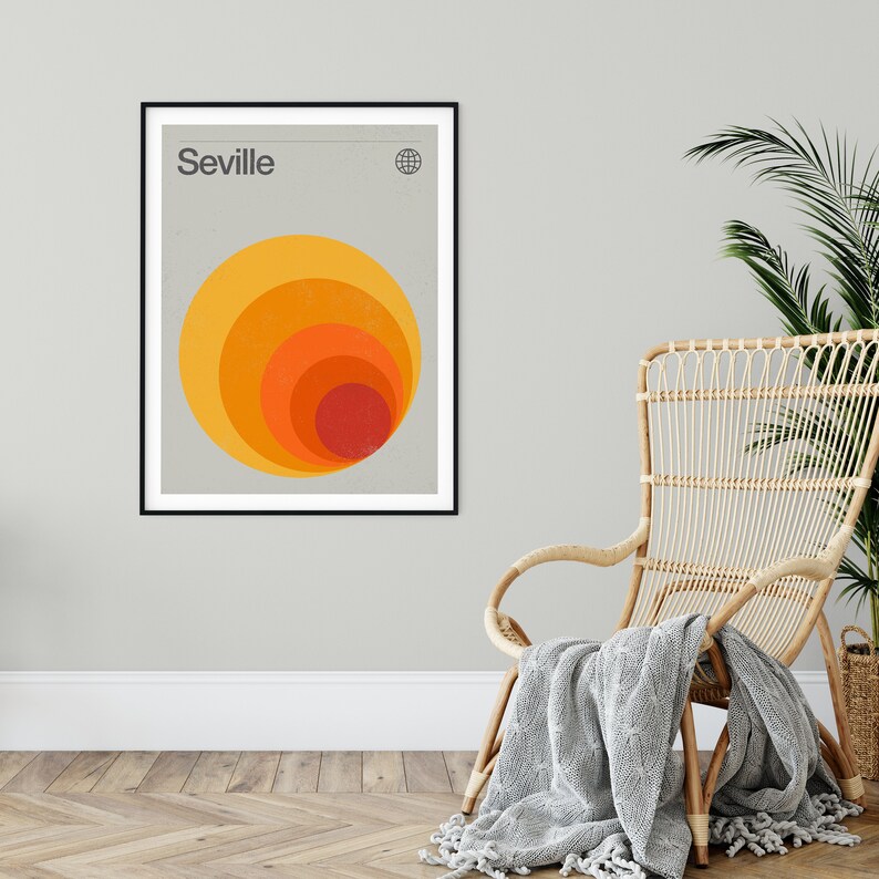 May include: A minimalist poster with the word "Seville" in black text at the top. A stylized graphic of concentric circles in shades of orange, yellow, and red is centered on the poster.
