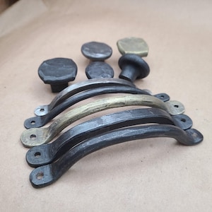 May include: A set of five black and gold metal cabinet pulls. The pulls are all different sizes and shapes, but they all have a rustic, hand-forged look. The pulls are perfect for adding a touch of industrial style to any home.