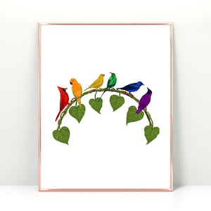 May include: A framed art print depicting seven vibrantly coloured birds on a green vine. The birds are red, orange, yellow, green, blue, and purple. The artwork has a white background and a rose gold frame.