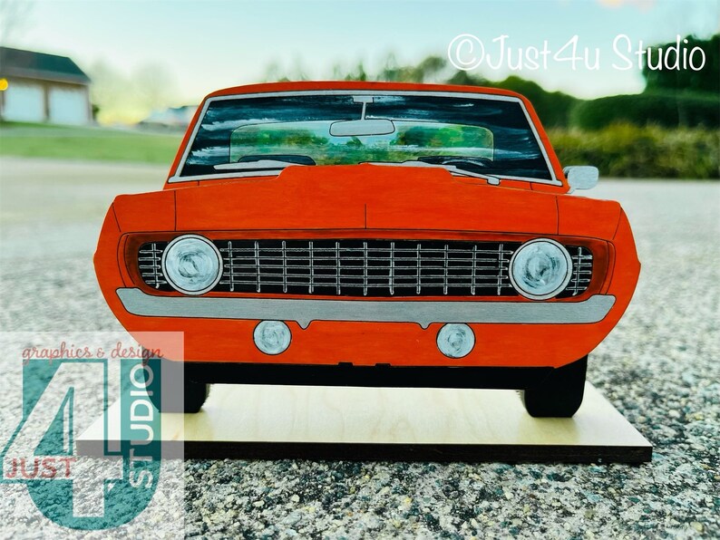 May include: A red vintage muscle car model with a black grille and chrome accents. The car is sitting on a wooden base. &copy;Just4U Studio
