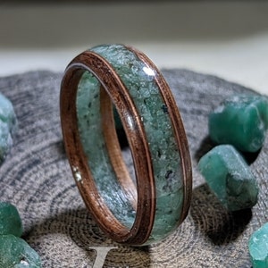 May include: A wooden ring with a green gemstone inlay. The ring is 8 1/2 US size and 6 mm wide. Example Rings: Size 8 1/2US Width 6mm Full list of gemstone options can be seen in shop. Klaus ewelers