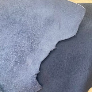 May include: Two pieces of blue leather, one smooth and one suede, are shown together. The suede leather is a lighter shade of blue.
