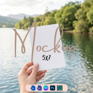 May include: A hand holds a white 5x7 inch mockup card against a blurred background of a lake and trees. The word "Mockup" is written in a cursive font over the card. Below the card, there are icons for JPG, PSD, Canva, Ps, and a design tool.