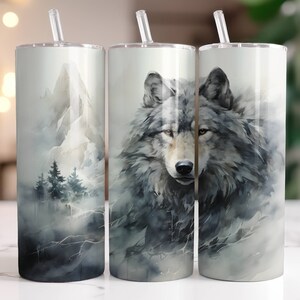 May include: Three stainless steel tumblers with lids and straws. The tumblers feature different designs. One has a watercolor mountain scene, another has a watercolor wolf, and the third has a watercolor wolf with a mountain scene in the background.