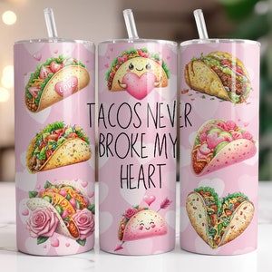May include: Three pink stainless steel tumblers with a white background and colorful illustrations of tacos. The tumblers have the text "Tacos Never Broke My Heart" printed on them.