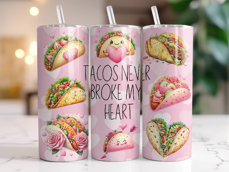 May include: Three pink stainless steel tumblers with a white background and colorful illustrations of tacos. The tumblers have the text "Tacos Never Broke My Heart" printed on them.