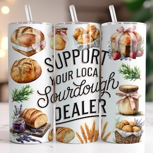 May include: Three white tumblers with lids and straws. The tumblers have a watercolor design of bread, flowers, and the text "Support Your Local Sourdough Dealer".