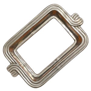 Puede incluir: Un marco de fotos rectangular plateado con un diseño ondulado y acanalado. El marco tiene esquinas redondeadas y detalles decorativos en forma de onda en la parte superior e inferior. El marco está vacío, con un fondo blanco visible a través de la abertura.