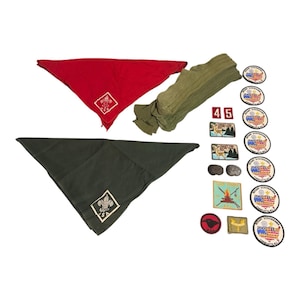 Puede incluir: Colección de artículos de Boy Scouts vintage, que incluye un pañuelo rojo y verde, calcetines verde oliva y varios parches. Los pañuelos presentan el logotipo de BSA. Los parches incluyen el número 45, un ciervo y otros diseños relacionados con los scouts.