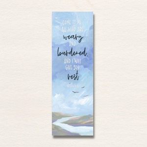May include: A rectangular bookmark featuring a blue sky with clouds and a landscape with a river at the bottom. The text reads: Come to me all who are weary and burdened. And I will give you rest. Matthew 11:28. Three small birds fly in the sky.