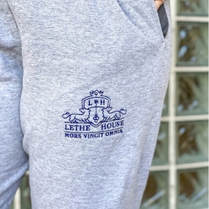May include: Grey sweatpants with a blue embroidered logo that says "Lethe House" and "Mors Vincit Omnia".